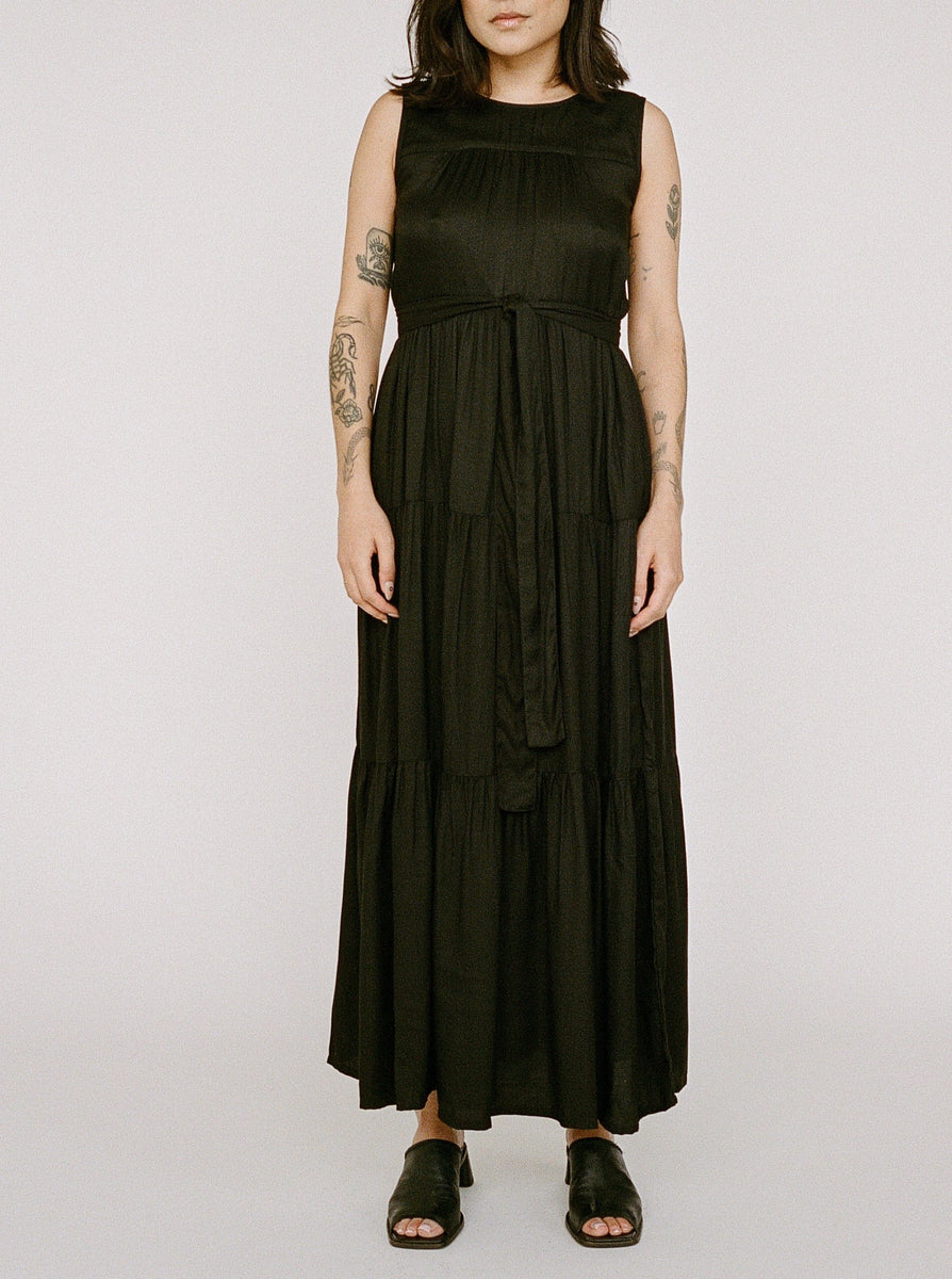 Woman in a Tiered Maxi Dress - Black standing against a plain background.