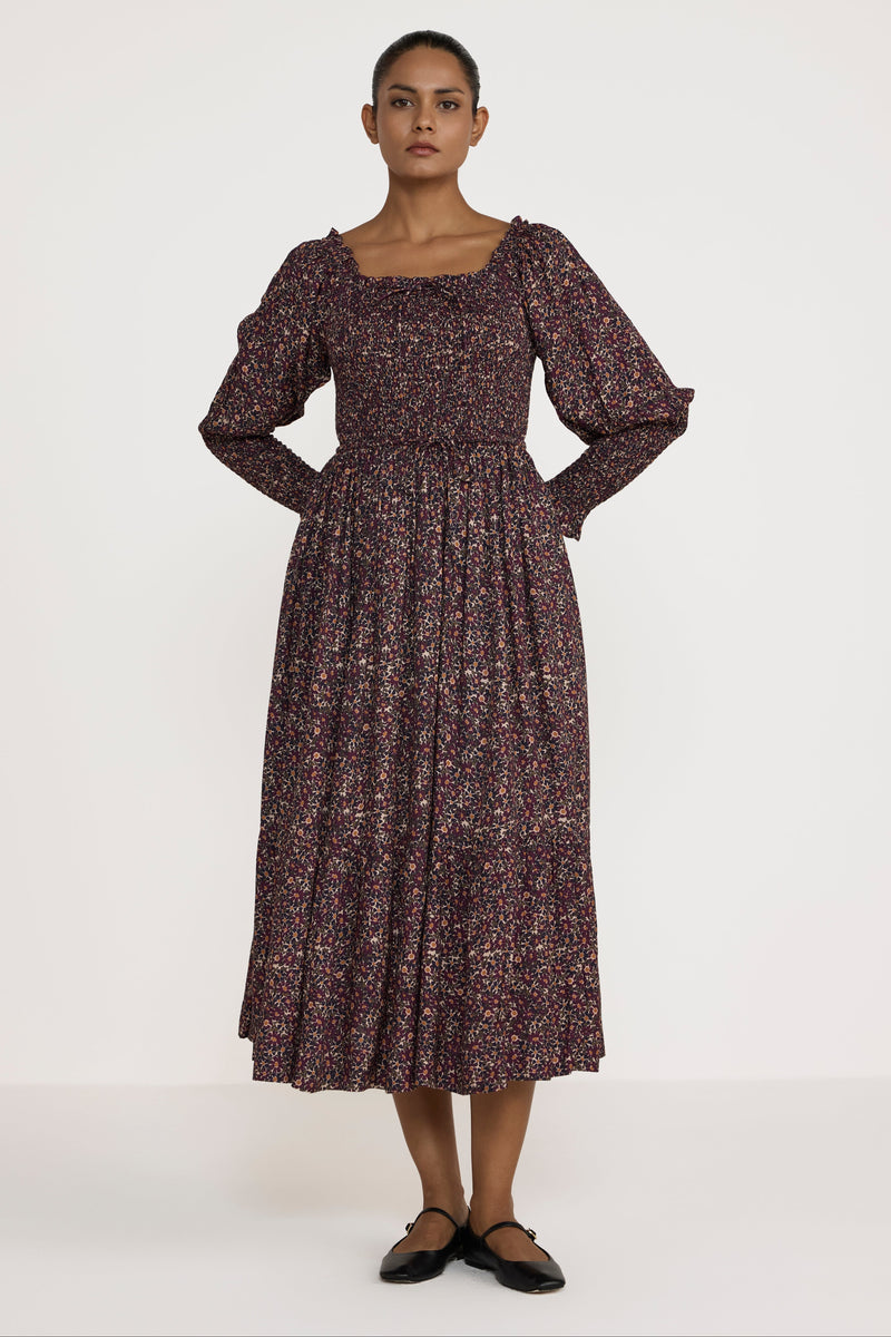 Woman wearing a patterned dress on a white background