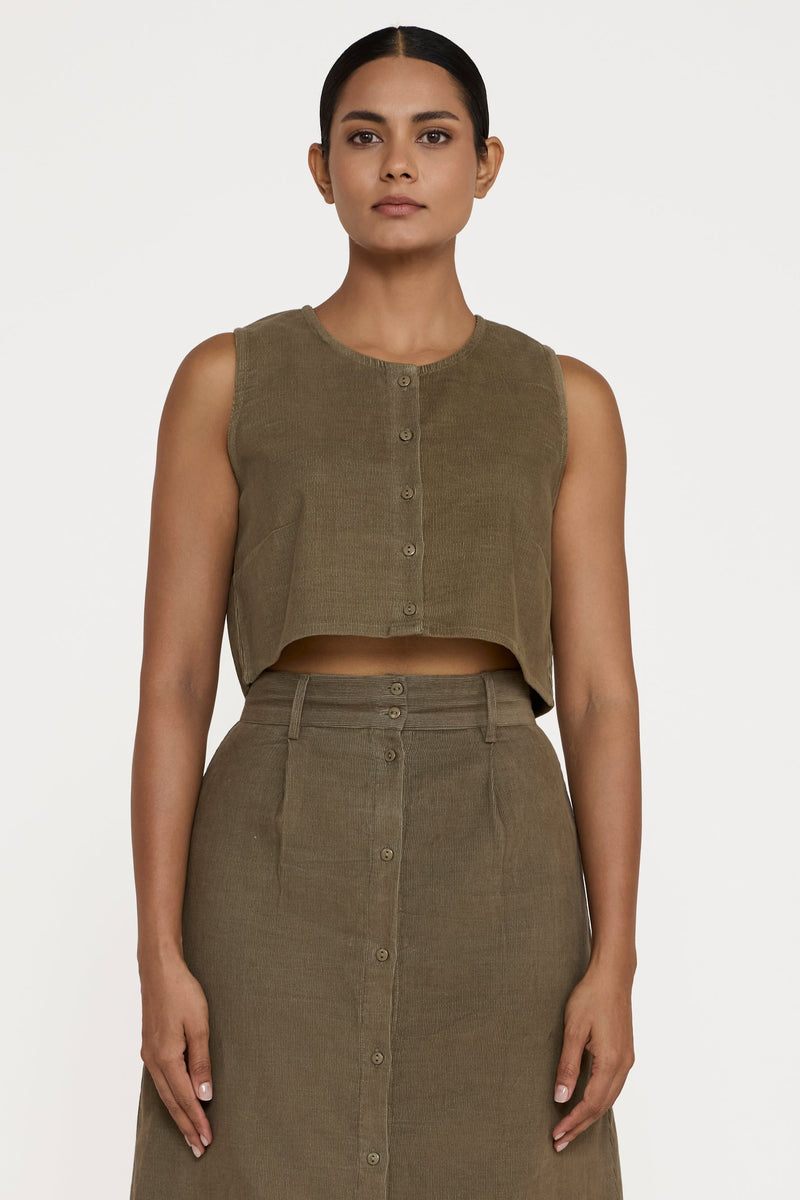 Woman wearing a matching olive green sleeveless top and skirt on a white background