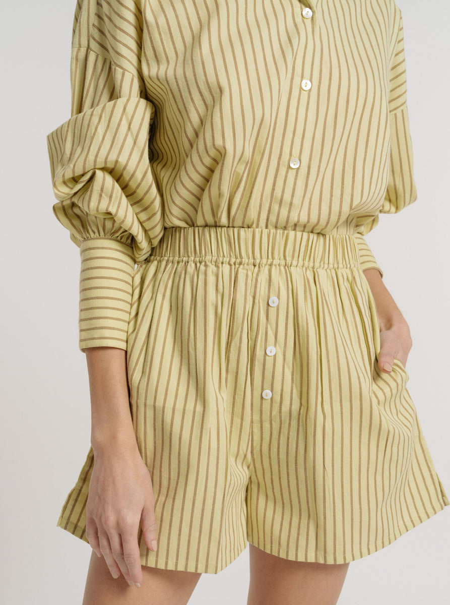 The model is wearing a yellow striped cotton poplin shirt and Easy Short - Feather Grass Stripe.