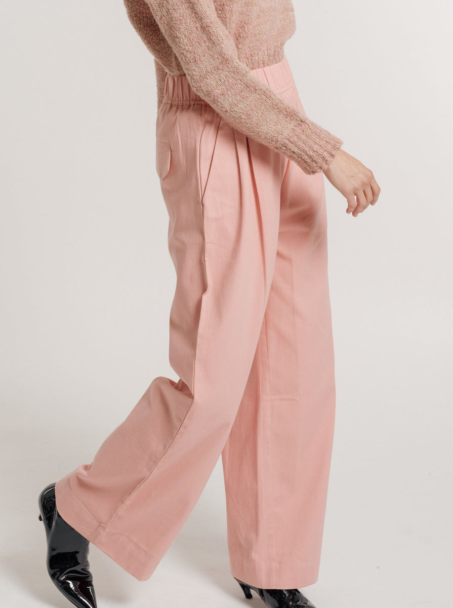 The model is wearing a pink sweater and Hepburn Trouser - Pincushion Pink.