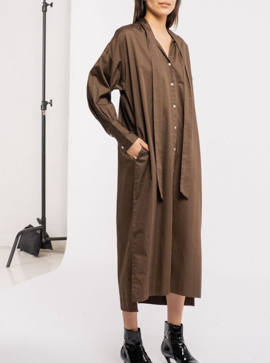 The model is wearing a Dolores Dress - Balsalt Brown - pre-order with poplin midi length.