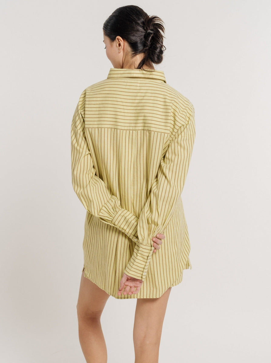The back view of a woman wearing a Museo Button Up - Feather Grass Stripe.