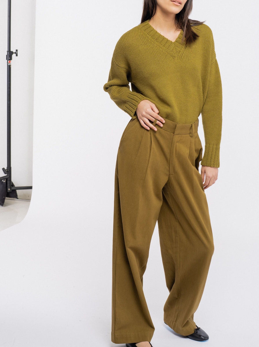 The model is wearing Alfred Trouser - Olive made of organic cotton.