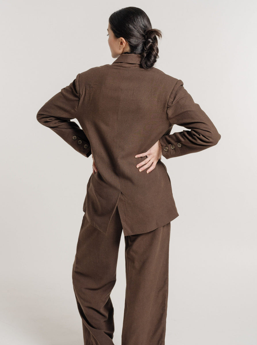 The woman wearing the Bea Blazer - Basalt Brown showcases a tailored waist and double-breasted shape.