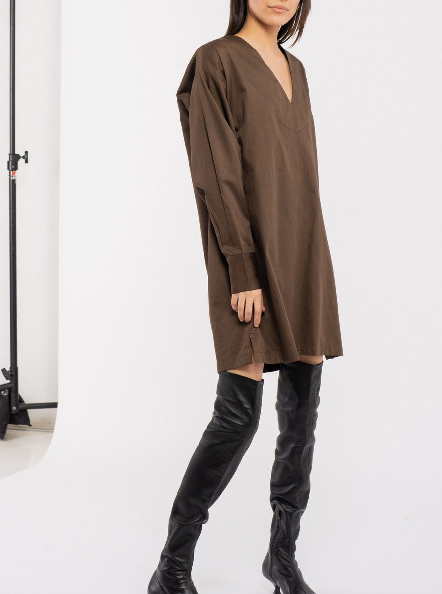 The model is wearing a Modern Tunic Dress - Basalt Brown paired with thigh high boots.
