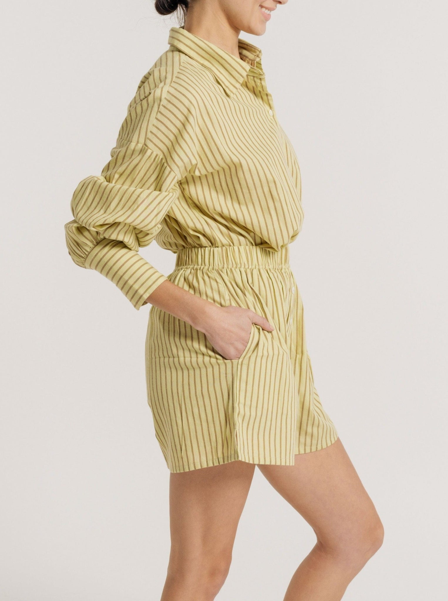 SEO product description: The Easy Short - Feather Grass Stripe - Sample is wearing a yellow striped romper.