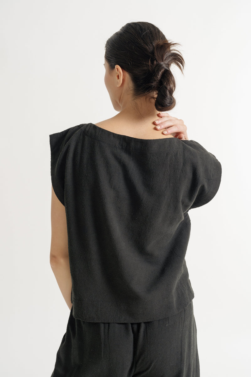 The back view of a woman wearing the Everyday Top - Black Silk Noil - Pre-order.
