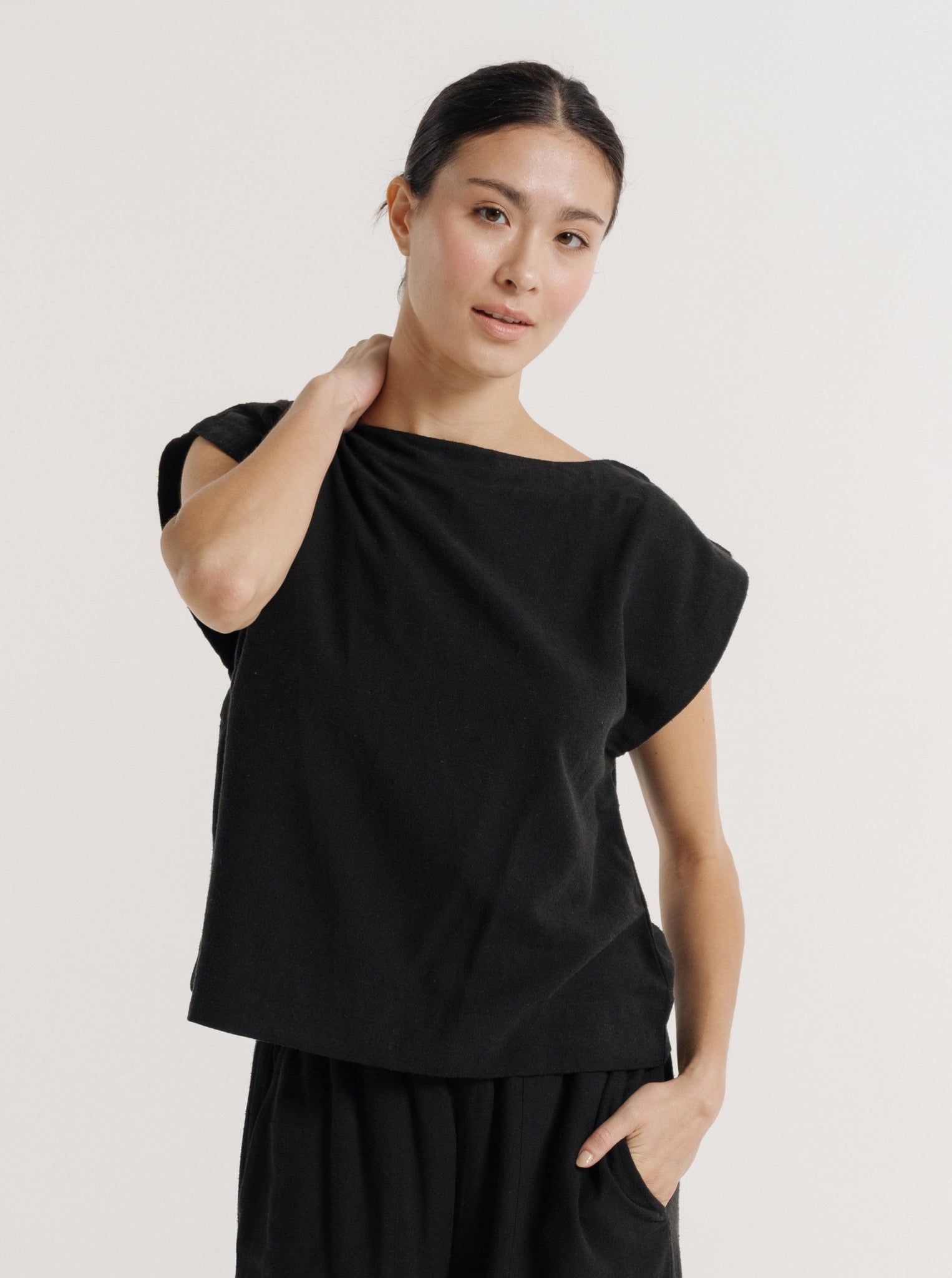 A woman wearing the Everyday Top - Black Silk Noil, showcasing sustainable fashion.