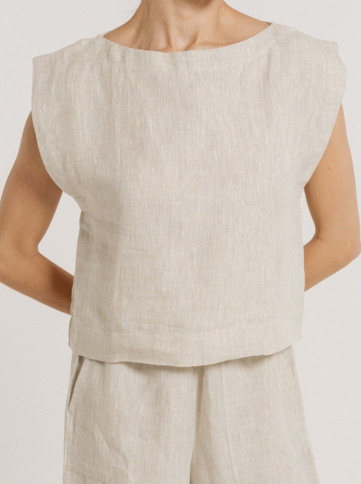 A woman wearing a certified organic linen beige Everyday Top - Natural Linen.