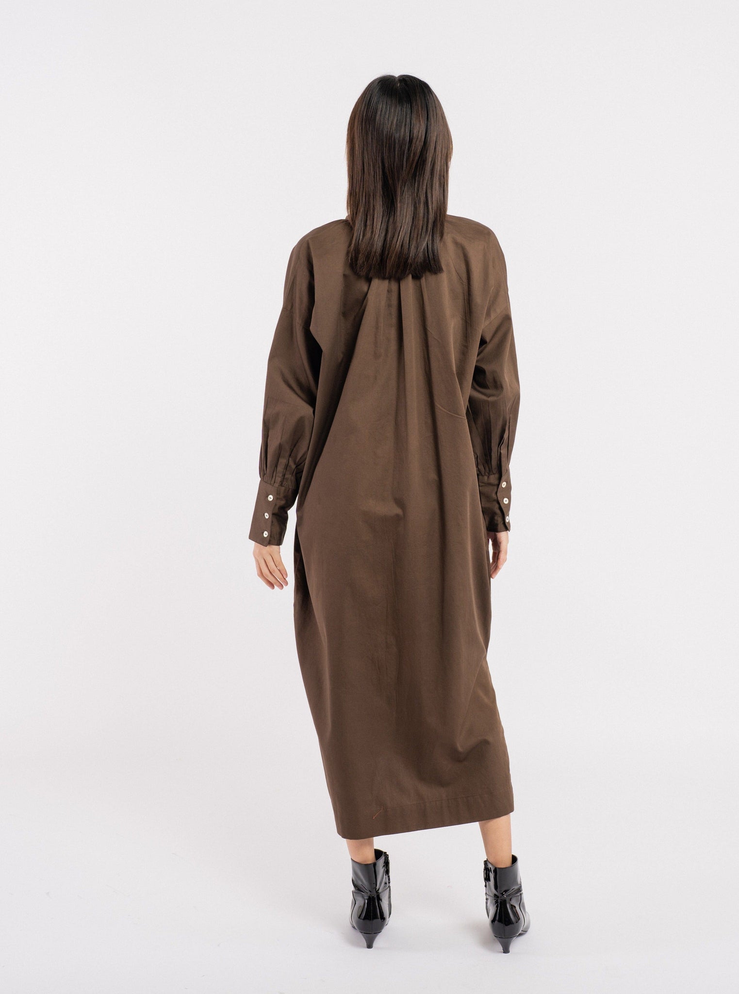 The Dolores Dress - Balsalt Brown - Sample is worn by a woman, made from organic cotton.