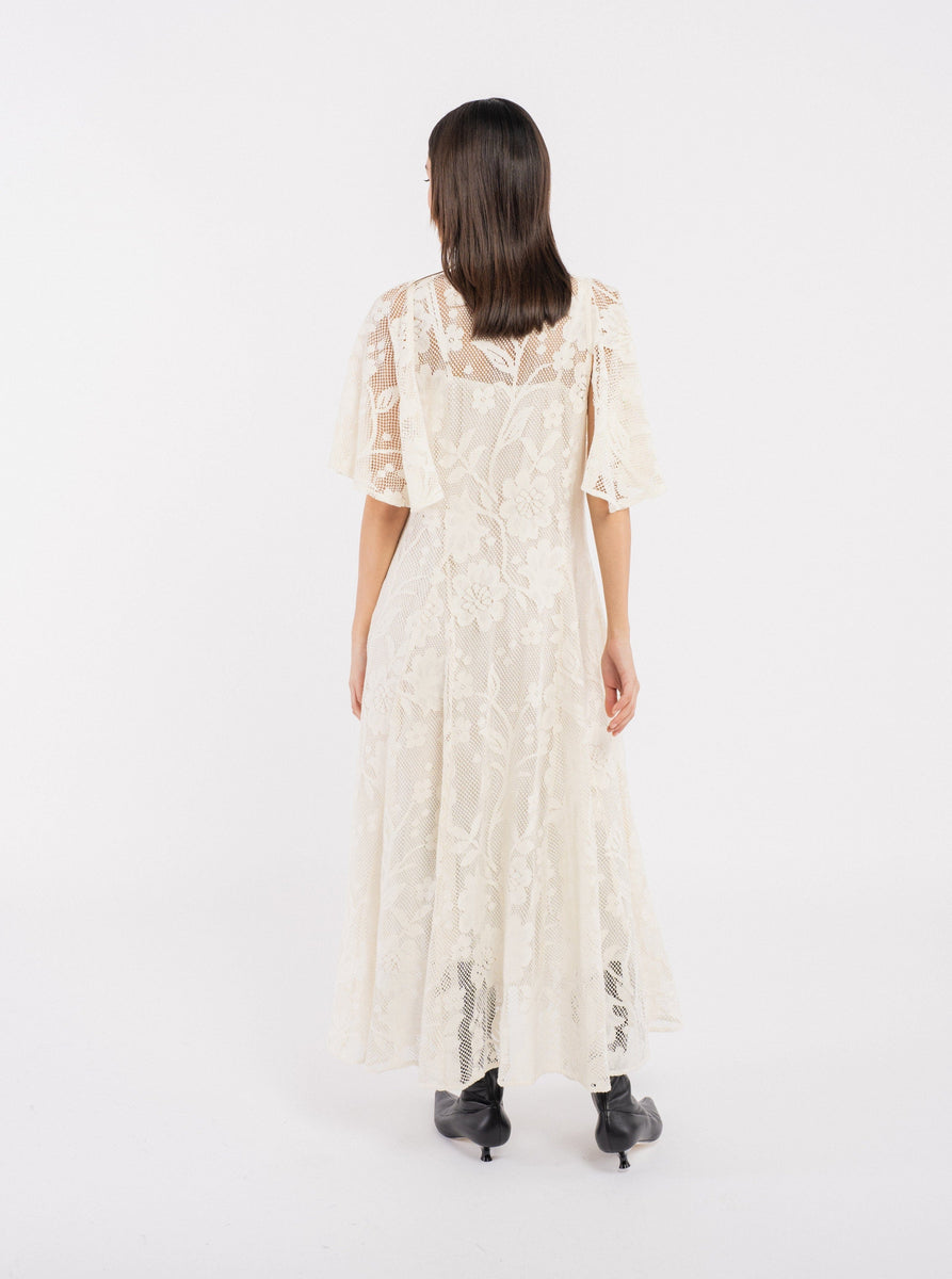 The back view of a woman wearing the Ailes Dress - Bone.