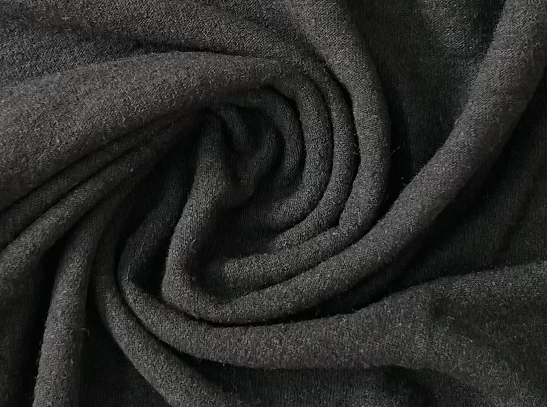 A close up of a handmade Baby Tee - Black, showcasing its sustainability aspect.