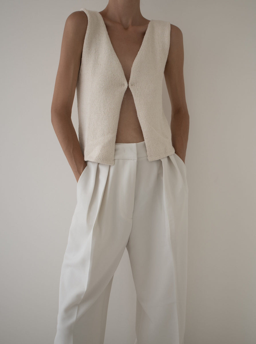 A woman wearing white pants and the Ida Keyhole Vest - Ivory.