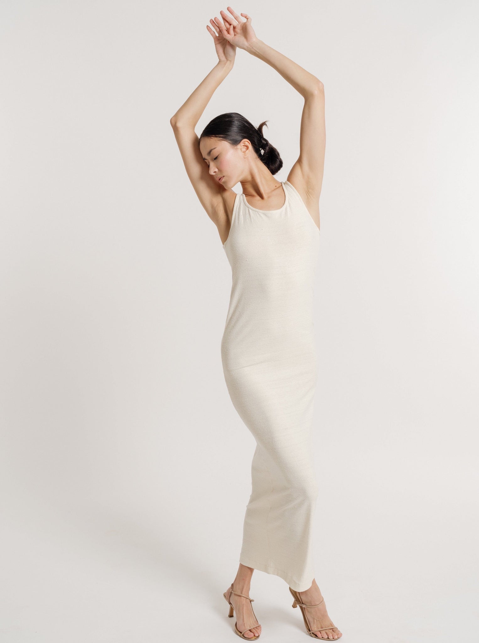 The model is wearing a sustainable, one-of-a-kind Jersey Knit Tank Dress - Ivory Silk Noil - Pre-order in cream.