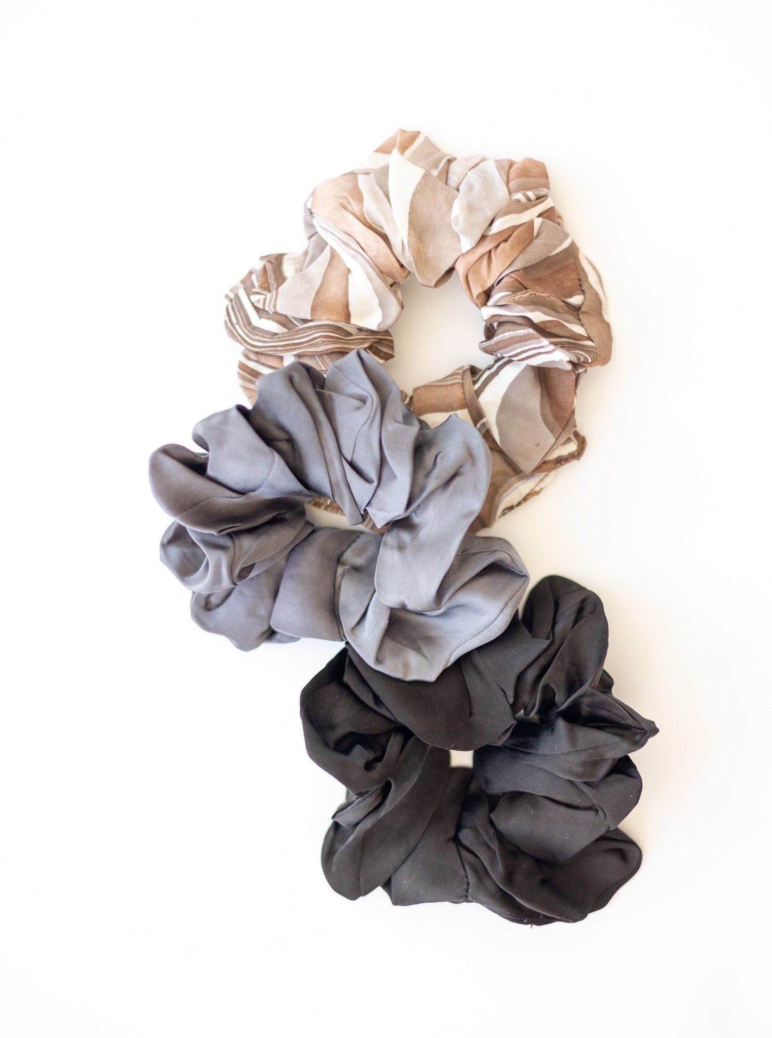 Three Small Scrunchies (set of 3) made from remnant fabrics, featured in an apparel collection, displayed on a white surface.