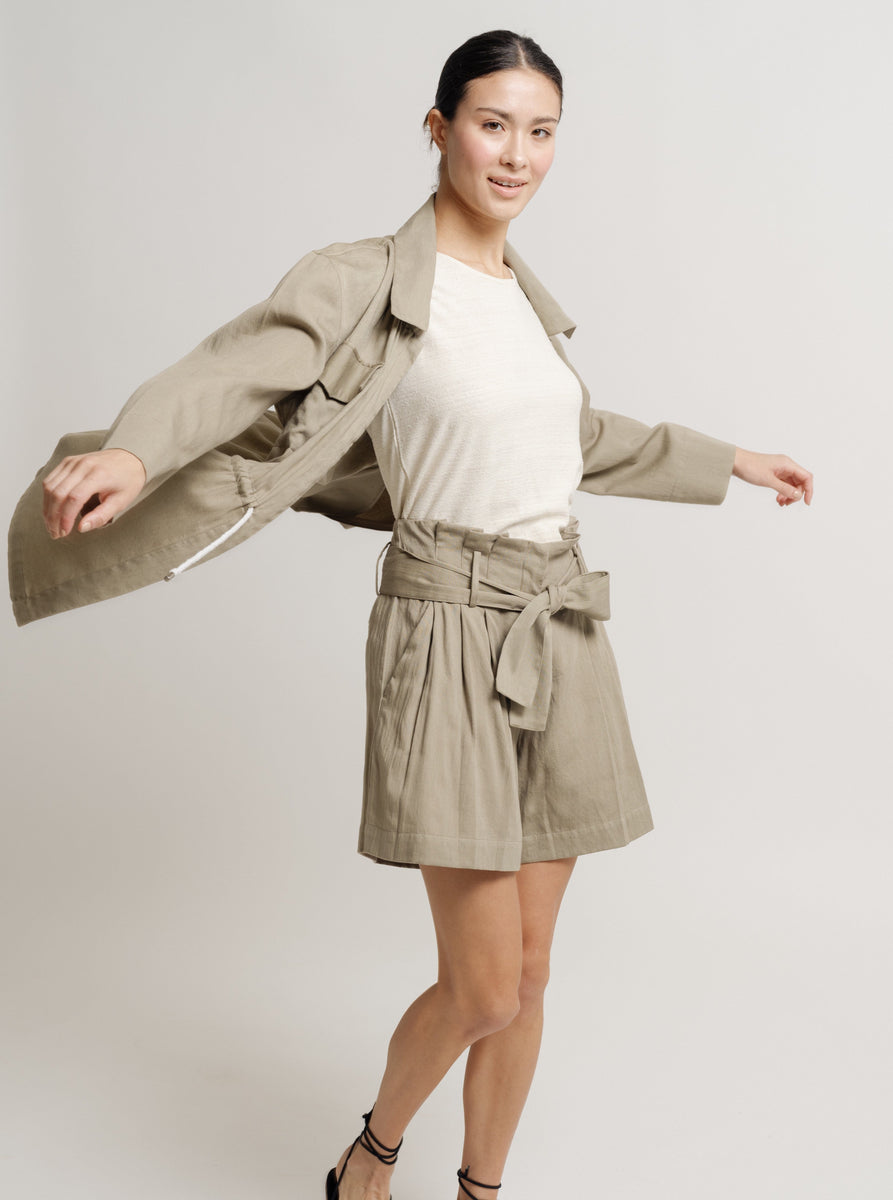 The model is wearing Paper Bag shorts with a khaki trench coat.