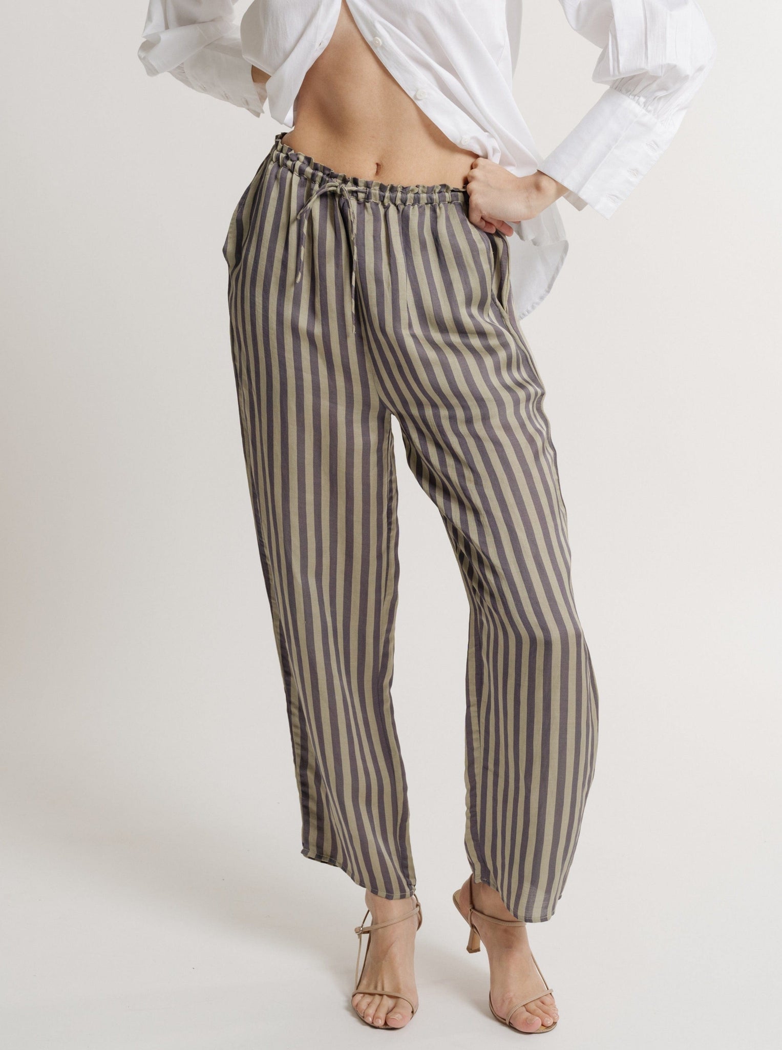 The model is wearing a white shirt and the Urban Stripe - Pre-order Cropped Ruffled Waist Tie Pant.