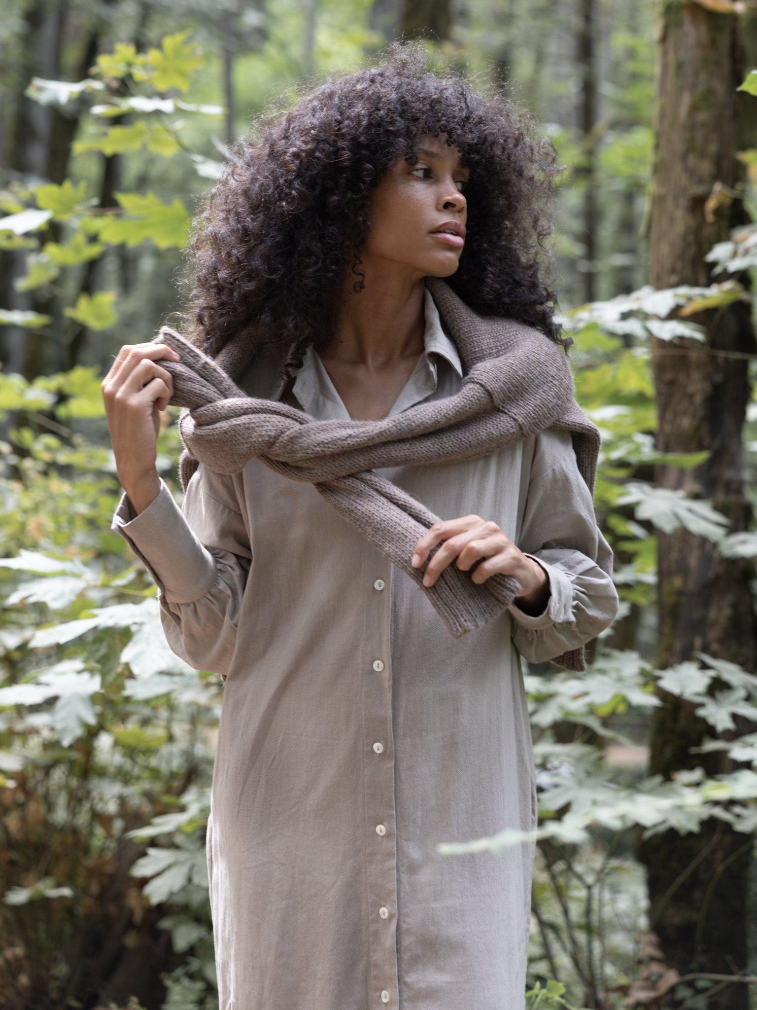 A woman wearing a Dillon Dress - Mushroom - XXL - Sample and scarf explores the woods.