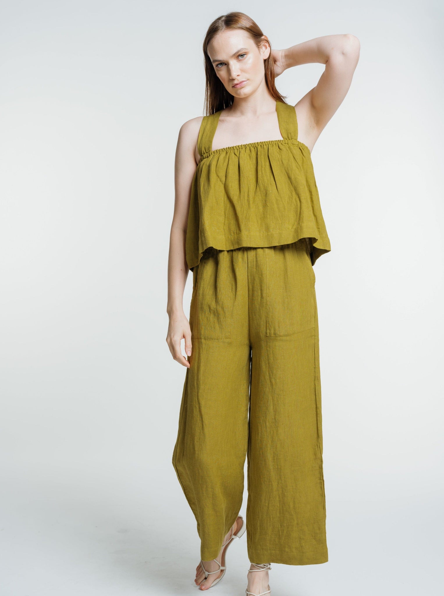 The model is wearing a high-waisted green Everyday Crop - Dried Tobacco - Sample jumpsuit.