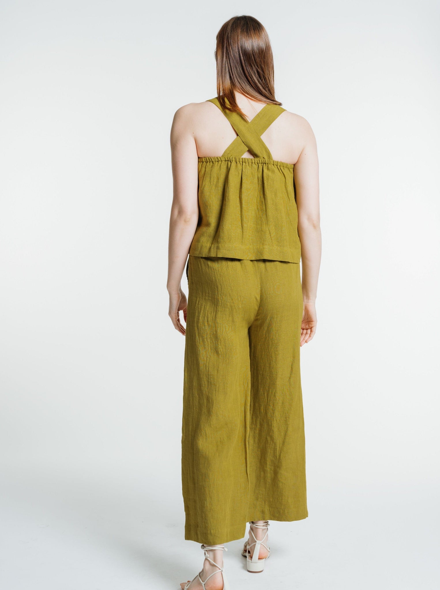 The back view of a woman wearing an Everyday Crop - Dried Tobacco jumpsuit.