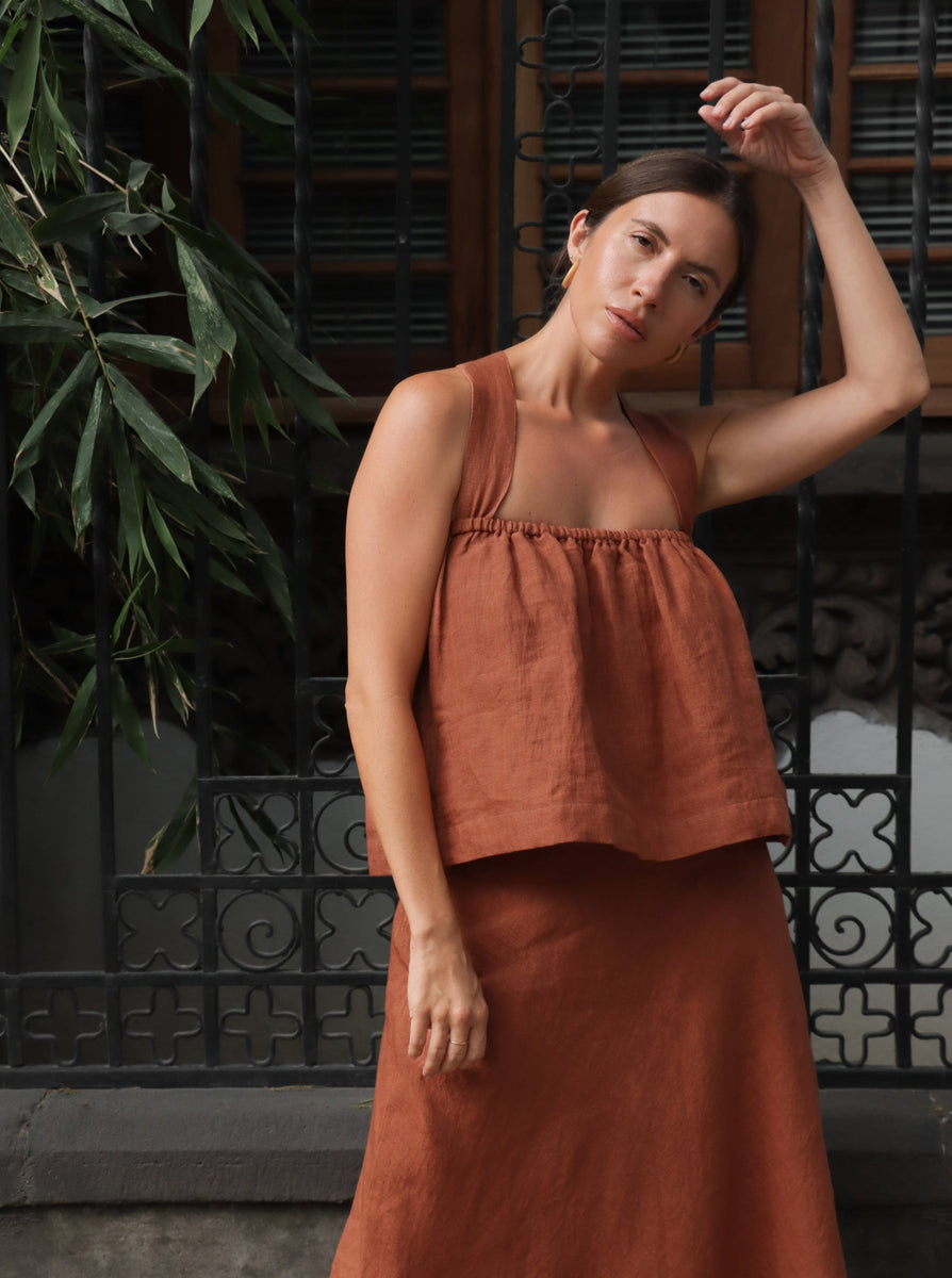 A woman is posing for a photo in an amber brown *Breeze Tank* dress.
