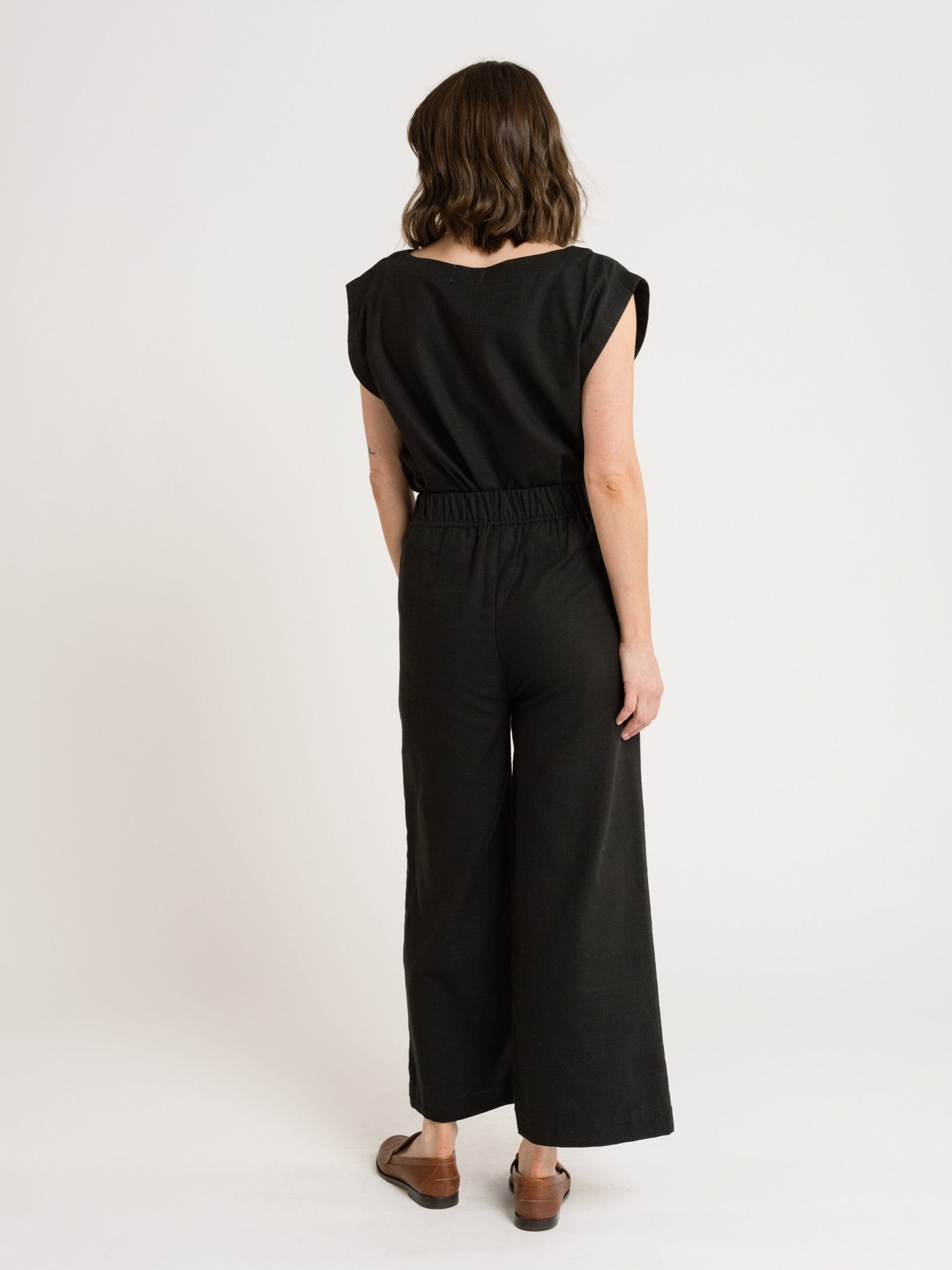 The back view of a woman wearing an Everyday Top - Black.