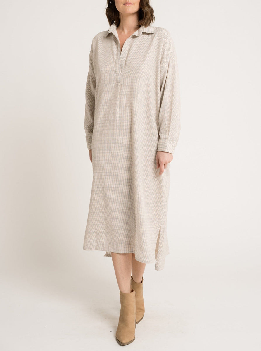 The model is wearing a Oversized Tunic Dress - Dove Small Grid in beige.