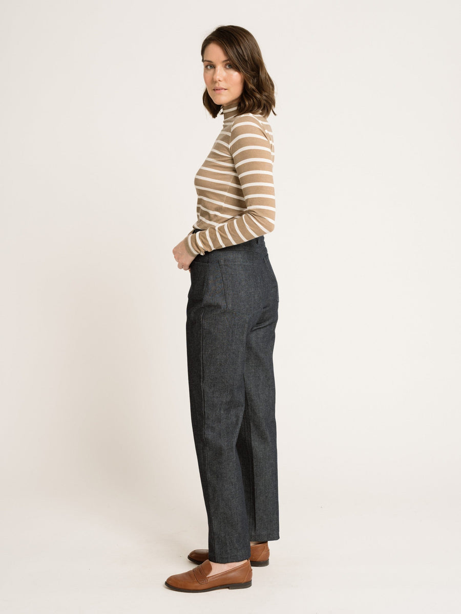 A woman wearing a striped top and jeans tries on a Sample 144 - Mock Neck Long Sleeve Tee - Tannin Stripe.