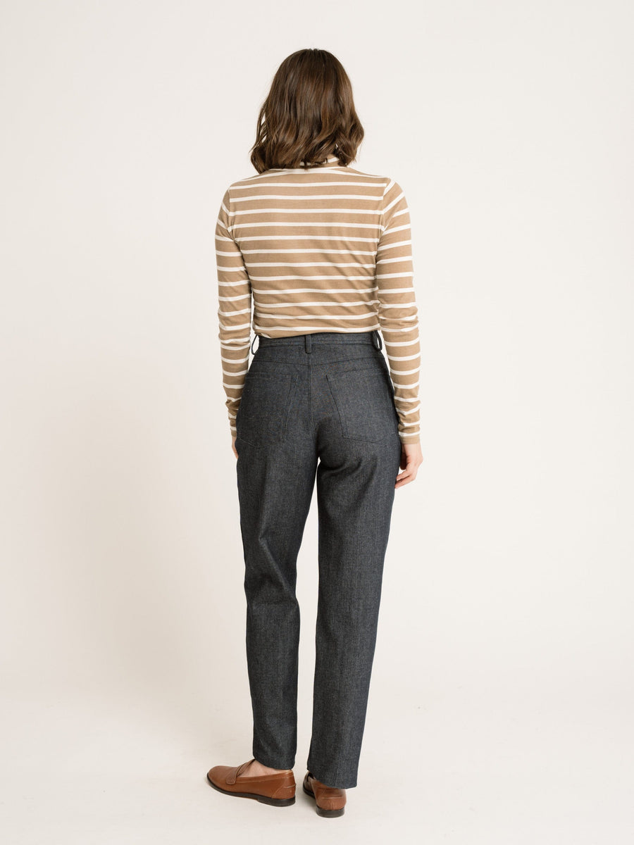 The back view of a woman wearing jeans and a Sample 144 - Mock Neck Long Sleeve Tee - Tannin Stripe shirt, showcasing the fit.