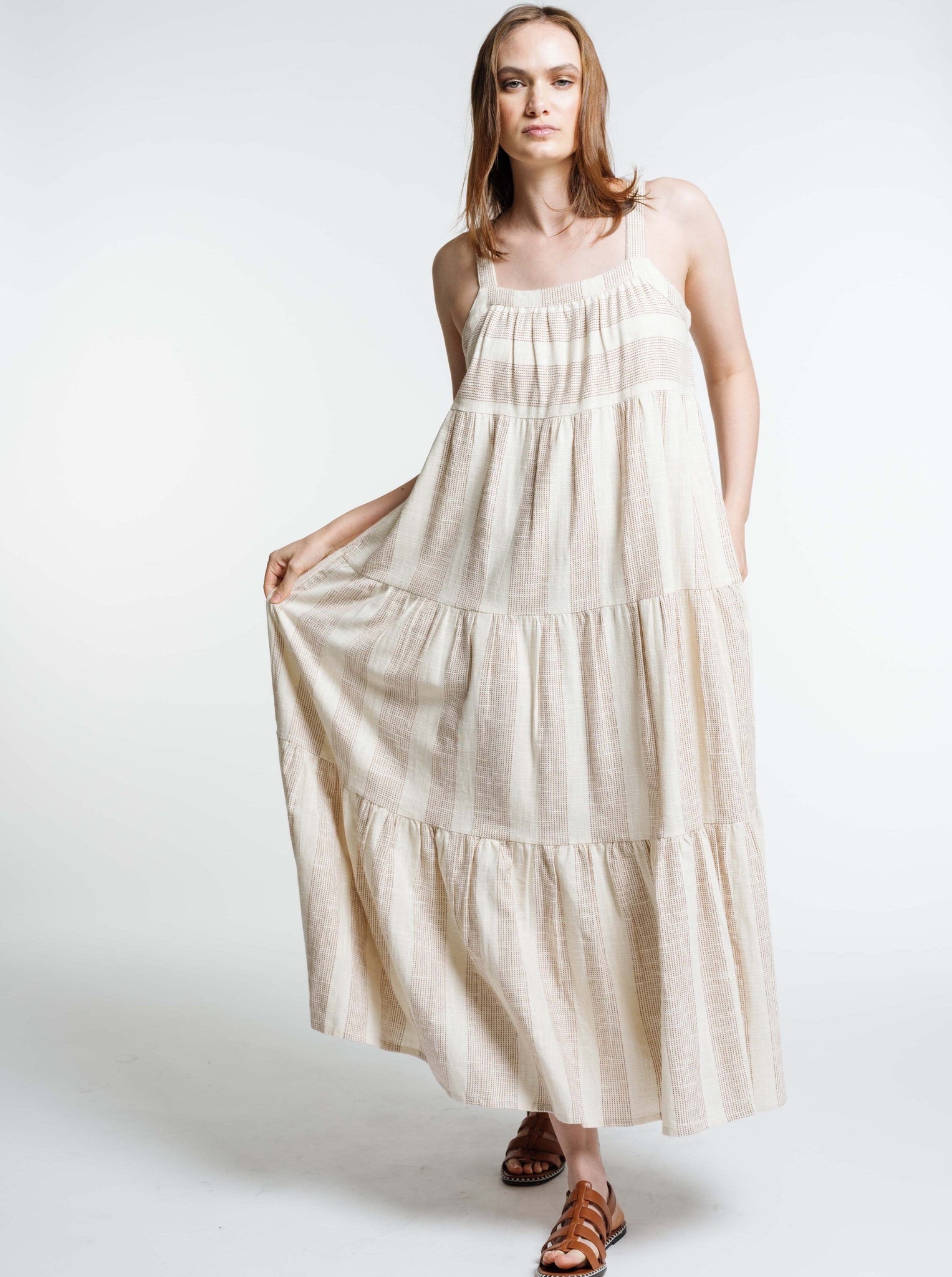 The model is wearing a Strappy Tiered Maxi Dress - Terracotta Ticking Stripe with ruffles and sandals.