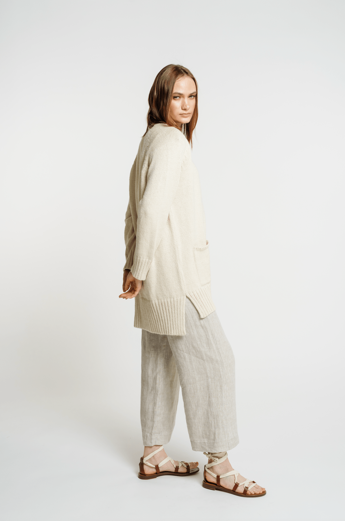 The model is wearing a Valley Cardigan - Vanilla and pants.