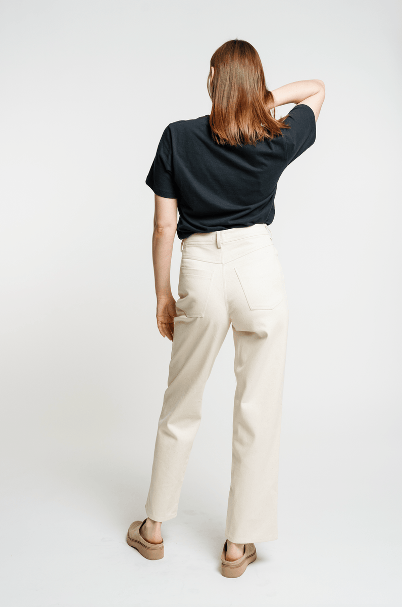The woman is seen from the back wearing Camp Pant - Bone - Sample.