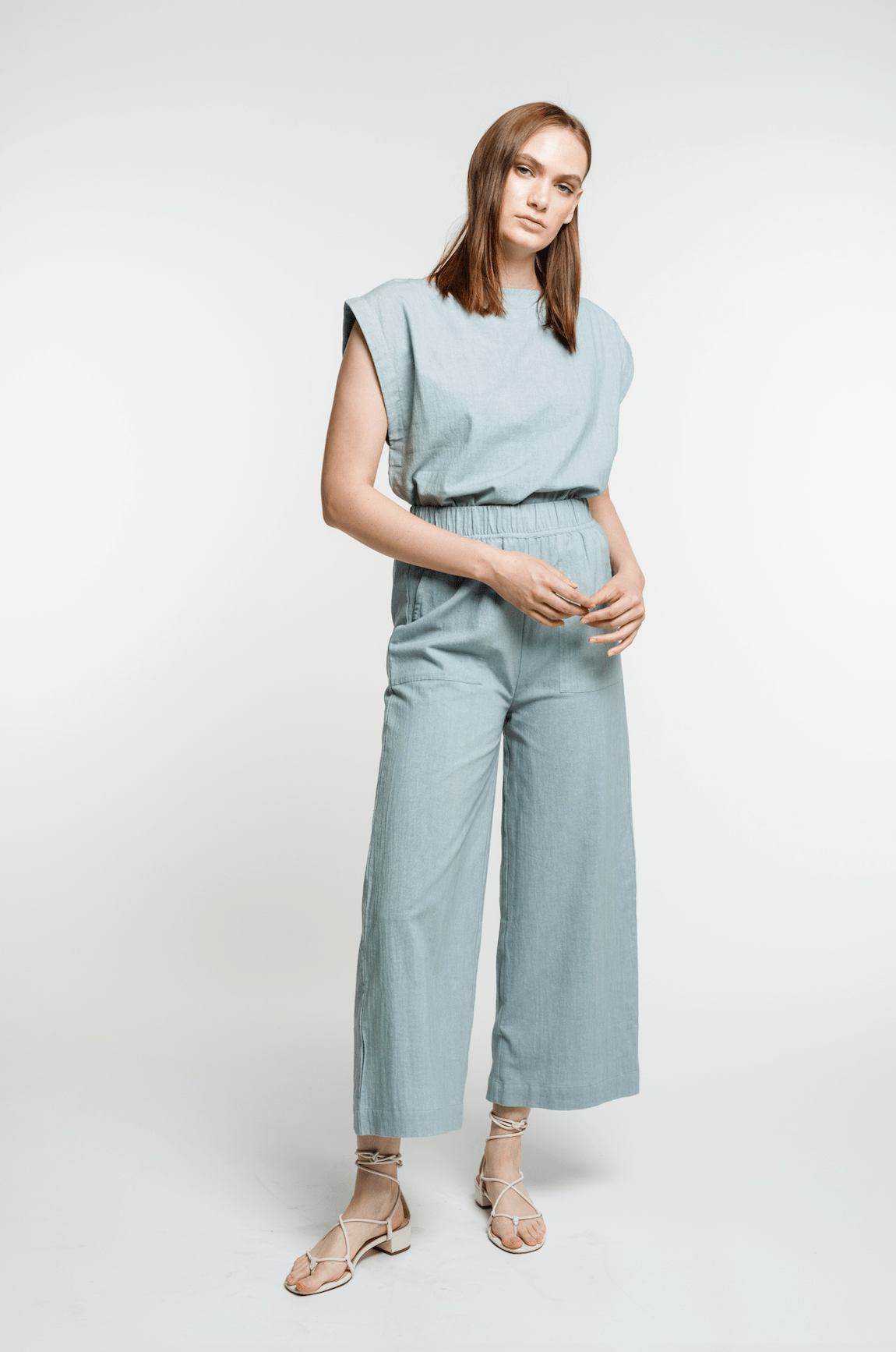 The model is wearing the Everyday Crop Pant - Cielo and sandals.
