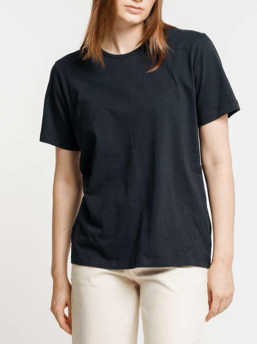 The model is wearing a sustainable black Crewneck T-Shirt.