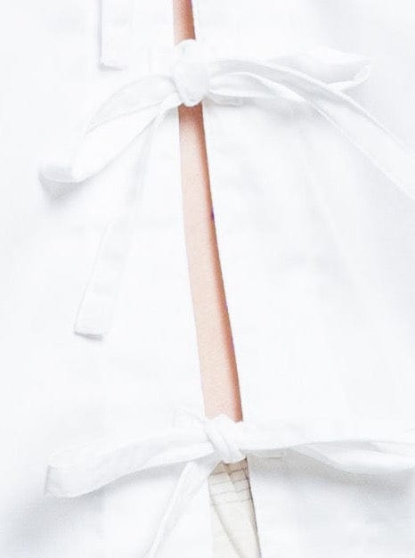 A close up of a Baker Top - White with a bow tie.