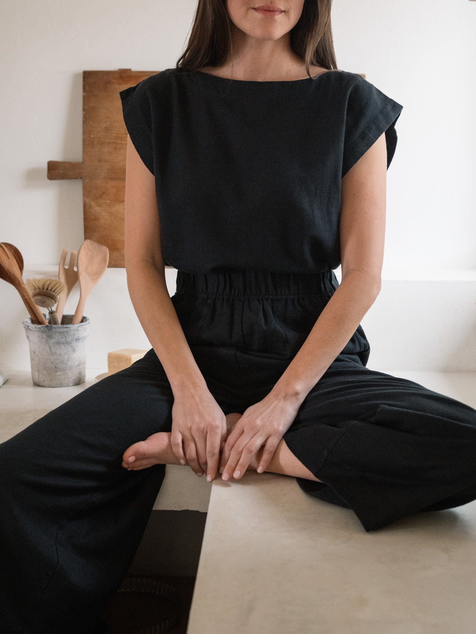 A woman sitting on a counter in an Everyday Top - Black.