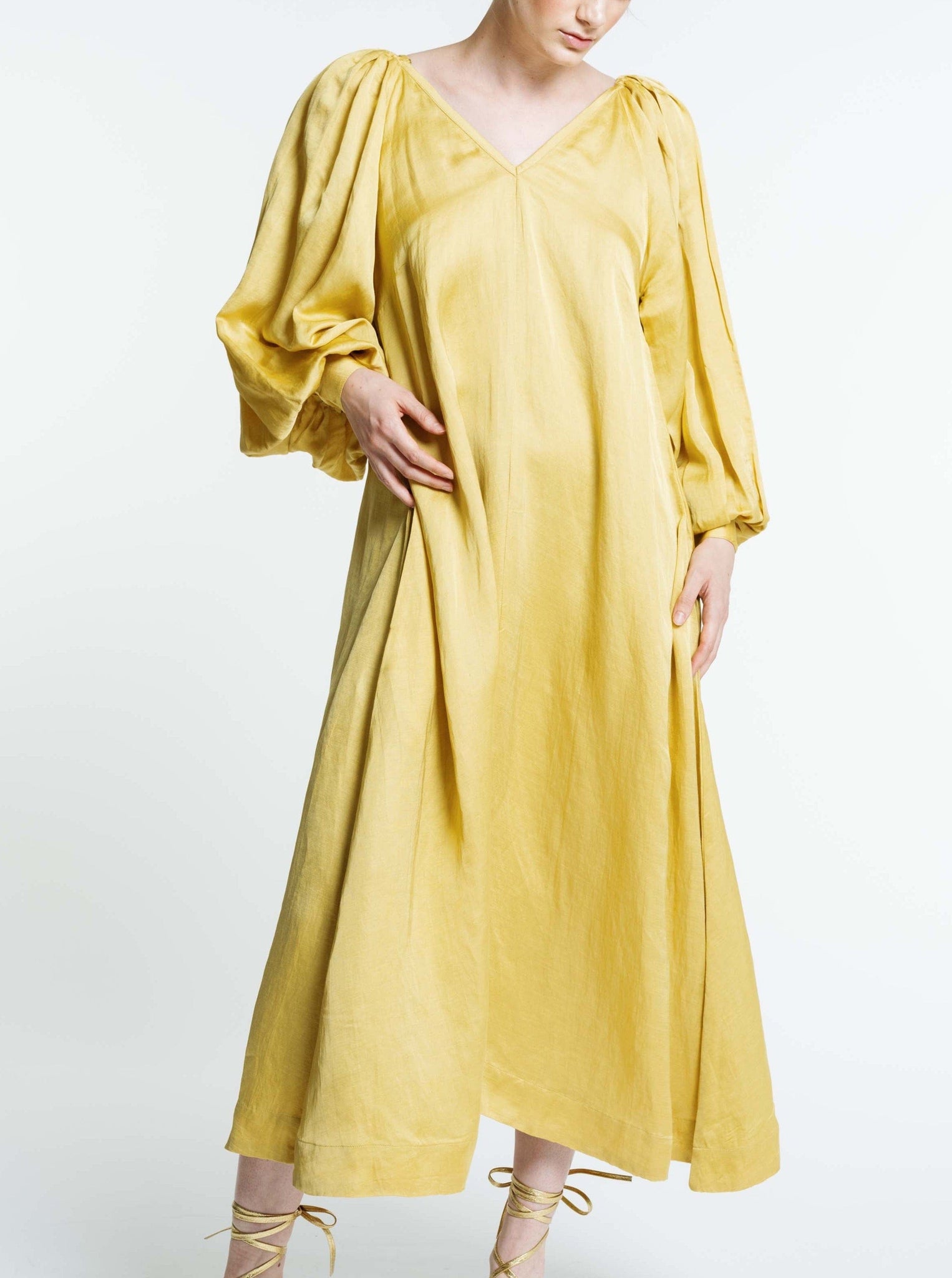 The model is wearing the Lupita Maxi Dress - Citrine with sleeve cuffs.